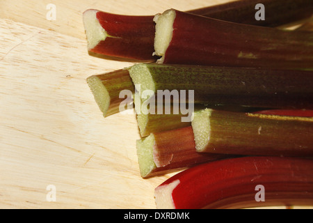 Gli stocchi di rabarbaro sul tagliere Rheum rhabarbarum Foto Stock