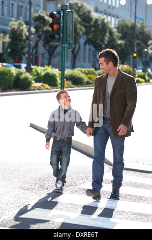 Padre e figlio camminando per strada Foto Stock