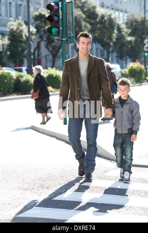 Padre e figlio camminando per strada Foto Stock