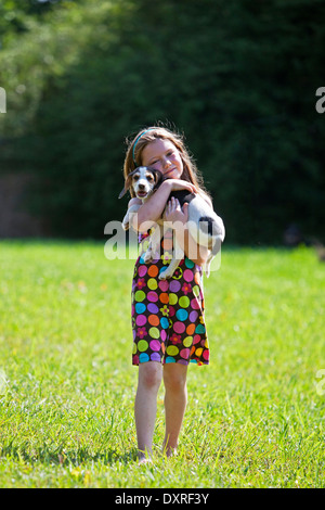 Giovane ragazza tenendo un cane cucciolo Foto Stock