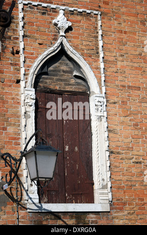 Antica facciata veneziana con finestra tradizionale e lanterna Foto Stock