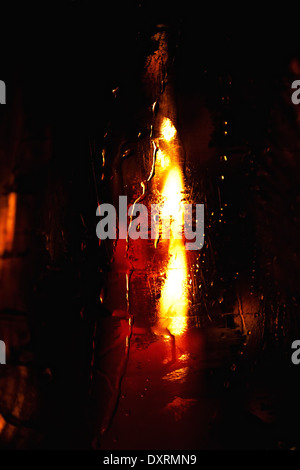 Candela brucia in un bicchiere bagnato closeup Foto Stock