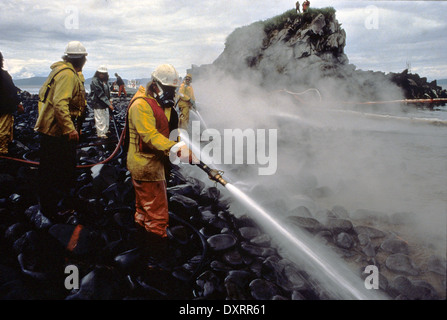 Lavoratori blast rocce e lavi giù il litorale imbevuto di olio grezzo utilizzando Corexit disperdente olio durante un test durante operazioni di pulitura del disco su Quayle Beach, Smith lsland dalla Exxon Valdez oil spill Agosto 8, 1989 in Prince William Sound, Alaska. La Exxon Valdez versato almeno 11 milioni di galloni di petrolio greggio nelle acque incontaminate di Prince William Sound il 24 marzo 1989. Foto Stock