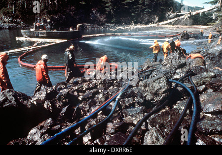 Lavoratori sbuffo di vapore rocce e lavi giù il litorale imbevuto di petrolio greggio dal perde petroliera Exxon Valdez dopo arenamento sul Bligh Reef in Prince William Sound fuoriuscita di almeno 11 milioni di galloni di petrolio greggio nelle acque incontaminate Marzo 28, 1989 in Prince William Sound, Alaska. Foto Stock