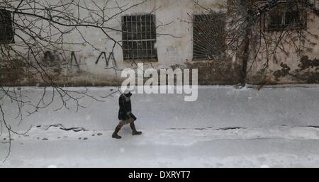 (140330) -- BAKU, Marzo. 30, 2014 (Xinhua) -- una donna passeggiate nella neve a Baku, capitale dell'Azerbaigian il 30 marzo 2014. Una neve pesante hits Azerbaigian oggi come le temperature goccia a 10 gradi in alcune regioni. (Xinhua) Foto Stock