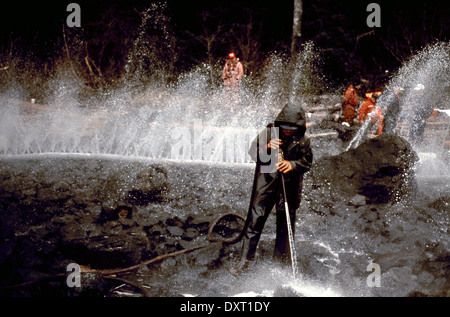 Lavoratori blast rocce e lavi giù il litorale imbevuto di olio grezzo utilizzando Corexit disperdente olio durante operazioni di pulitura del disco dalla Exxon Valdez oil spill Maggio 18, 1989 in Prince William Sound, Alaska. La Exxon Valdez versato almeno 11 milioni di galloni di petrolio greggio nelle acque incontaminate di Prince William Sound il 23 marzo 1989. Foto Stock