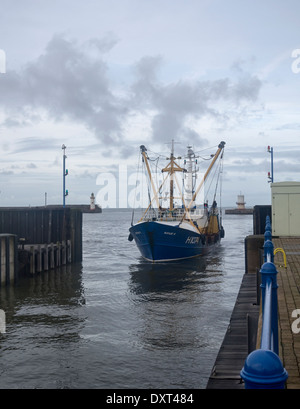 Un peschereccio blu entrando Whitehaven harbour serrature, di ritorno da un viaggio di pesca Foto Stock