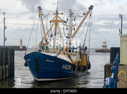 Un peschereccio blu entrando Whitehaven harbour serrature, di ritorno da un viaggio di pesca Foto Stock