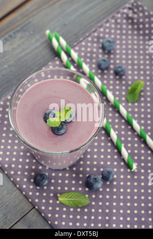 Frullato di mirtilli con bacche fresche e bevande cannucce su sfondo di legno Foto Stock