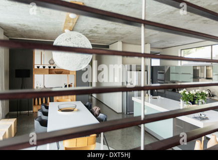 Vista della moderna sala da pranzo e cucina attraverso doghe in legno Foto Stock