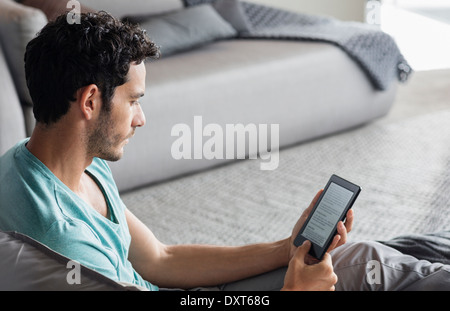 Uomo con tavoletta digitale in camera da letto Foto Stock