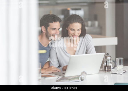 Giovane utilizzando il portatile in tabella Foto Stock