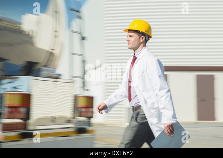 Scienziato in hard-hat a piedi con gli appunti Foto Stock