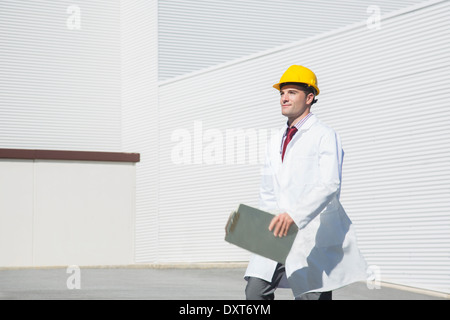 Scienziato in hard-hat con appunti passeggiate all'aperto Foto Stock