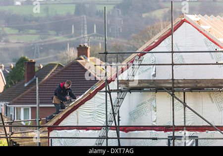L'uomo chiodatura manganelli per rivestimenti una nuova build sul tetto della casa, Llanfoist, Abergavenny, Wales, Regno Unito Foto Stock