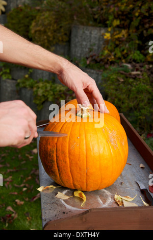 Persona carving Jack O'lanterna Foto Stock