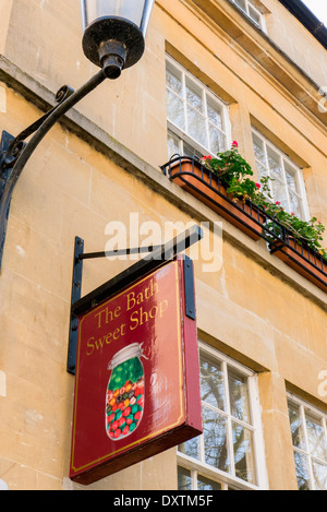 Vista di un colorato, pubblicità segno appesa sopra un dolce tradizionale negozio il Abbey verde nel cuore della città di Bath, Inghilterra, Regno Unito. Foto Stock