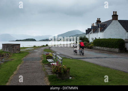 Tre i ciclisti prendere sulla Gran Bretagna più lunga strada in salita Lochcarron, Scozia Foto Stock