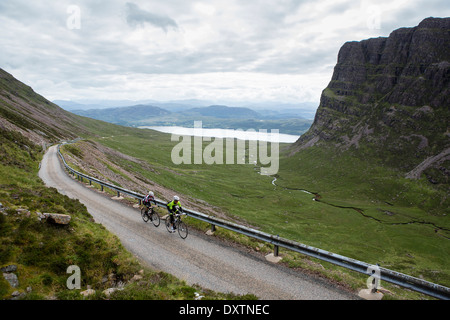 Due ciclisti prendere sulla Gran Bretagna più lunga strada in salita Lochcarron, Scozia Foto Stock