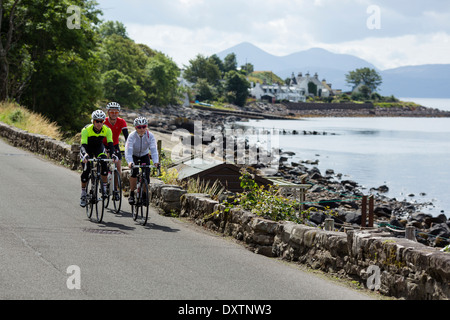 Tre i ciclisti prendere sulla Gran Bretagna più lunga strada in salita Lochcarron, Scozia Foto Stock