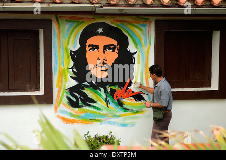 Ritratto artista che dipinge un murale di che Guevara, Cuba, Foto Stock