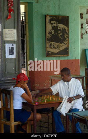 La gente del posto a giocare a scacchi in un club di scacchi con un poster di Che Guevara in background, Santiago de Cuba, Cuba Foto Stock