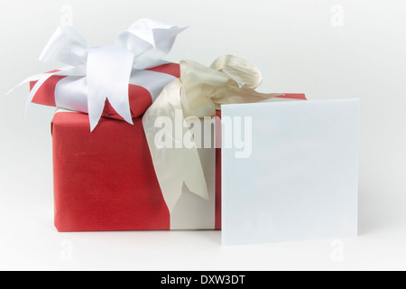 Due gift wrapped presenta con archetti e un biglietto di auguri in una busta Foto Stock