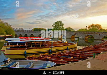 Clopton Bridge attraverso il fiume Avon nel cuore di Stratford upon Avon, Warwickshire, con una collezione di barche ormeggiate presto una mattina d'estate. Foto Stock