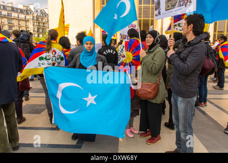 La folla di comunità etniche tibetane, taiwanesi e uigure della Francia, e di amici hanno dimostrato di mobilitarsi contro la visita del presidente cinese a Parigi, donna in velo che tiene bandiera nazionale in strada, protesta contro la cina, la francia musulmana, la solidarietà politica internazionale degli uiguri Foto Stock