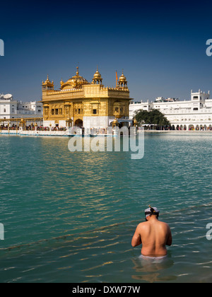 India Punjab, Amritsar e Sri o Harmandir Sahib Darbar, Tempio d'Oro Uomo Sikh di balneazione in Sarovar serbatoio santo Foto Stock