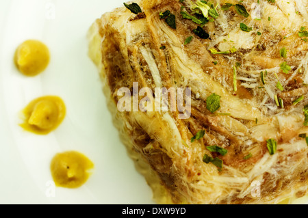 Gelificata, aspic cuocere dal manzo, maiale, pollo con senape su una piastra di close-up. Foto Stock