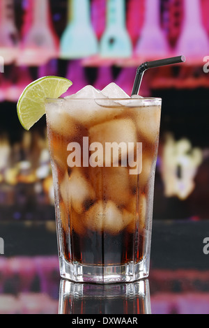 Il freddo cola drink in vetro con cubetti di ghiaccio in un bar o un party Foto Stock