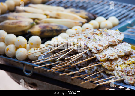 Grigliate gli spiedini di banana a una bancarella di strada a Bangkok, in Thailandia Foto Stock