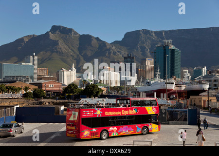 Bus rosso di City Sightseeing Cape Town e la skyline di Città del Capo, Western Cape, Sud Africa Foto Stock