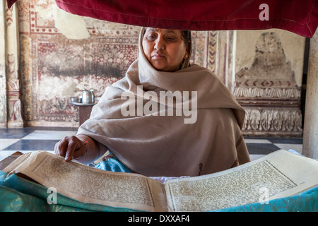 India, Dehradun. La donna la lettura della Sacra Scrittura nella Durbar Shri Guru Ram Rai Ji Maharaj, un tempio sikh costruito nel 1707. Foto Stock