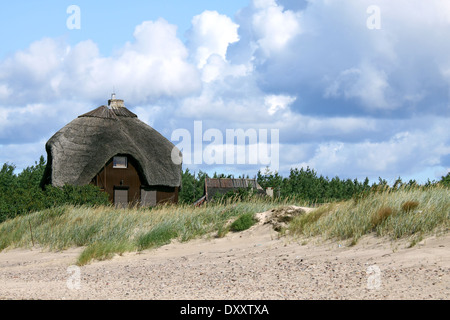 Casa sulla spiaggia con tetto in paglia in piedi le dune di sabbia Foto Stock