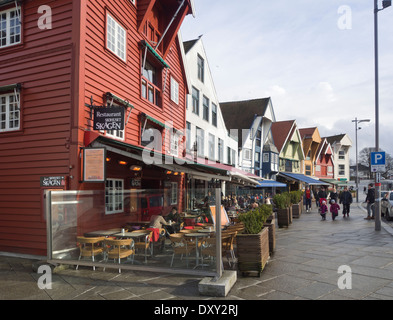 Ristoranti all'aperto in vecchi magazzini, le caffetterie e i bar attraggono visitatori ogni volta che il sole mette in un aspetto, Stavanger Norvegia Foto Stock