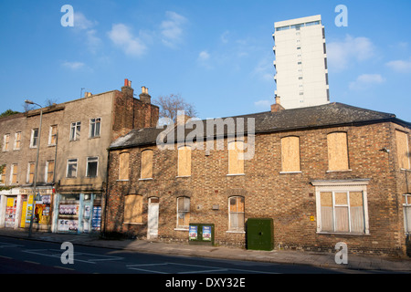 Fila di mattoni di case a schiera e ex negozio in attesa di demolizione con e moderno isolato a torre Battersea London Inghilterra England Regno Unito Foto Stock