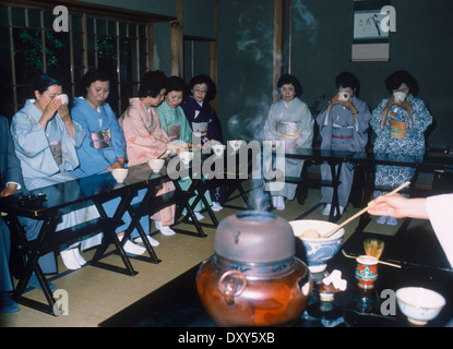 Donne che indossano kimono seduto in casa da tè in Tokyo, Giappone Foto Stock