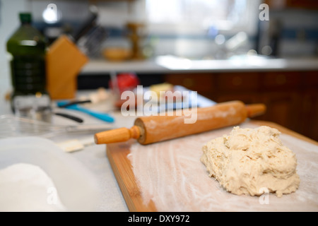 Freschi senza glutine impasto su un ripiano infarinato con pin di rullatura per la realizzazione di una casa fatta di pizza Foto Stock