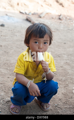 Bimba di tre anni pone per la fotocamera mentre si gusta un gelato di Huay Pakoot villaggio nel nord della Thailandia. Foto Stock