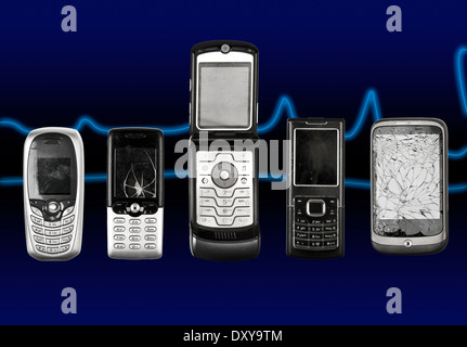 Vecchio e rotto i telefoni cellulari su uno sfondo blu Foto Stock
