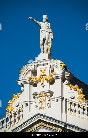 Una statua in piedi sulla cima di uno degli edifici hisotric sulla Grand Place (La Grand Place), un sito Patrimonio Mondiale dell'UNESCO nel centro di Bruxelles, Belgio. Foderato con ornati, edifici storici, il ciottolo square è la principale attrazione turistica di Bruxelles. Foto Stock