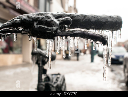 Un manubrio di bicicletta sono racchiusi nel ghiaccio con ghiaccioli dopo la tempesta di ghiaccio in primo piano Foto Stock