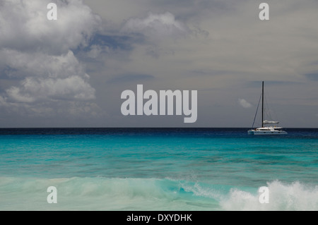 Barca a vela off di Petite Anse spiaggia di La Digue, Seicelle Foto Stock