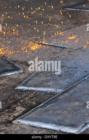 Le scintille volano come acciaio viene tagliata da un vecchio chiatta da un ossi-acetilene torcia presso un cantiere in Malaysia. Foto Stock