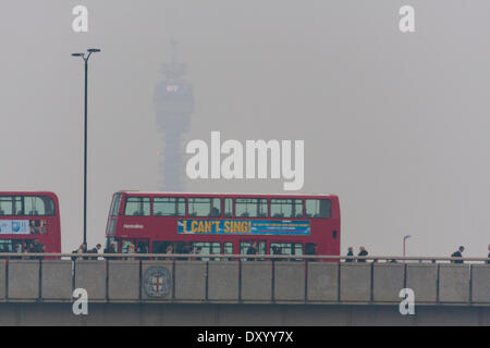 Londra, 2 aprile 2014. Pendolari cross London Bridge con la BT Tower in background offuscato dallo smog come l'inquinamento atmosferico da Europa e polvere dal deserto del Sahara tempeste di sabbia derive nel sud-est dell' Inghilterra.Livello di inquinamento sono in aumento i prossimi giorni. La scadente qualità dell'aria è la creazione di un haze in gran parte dell'Inghilterra. Credito: Paolo Davey/Alamy Live News Foto Stock