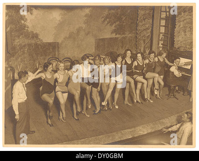 Un coro prova negli anni '1920 o '1930, catturato dal fotografo Sam Hood. L'immagine mostra un gruppo di ragazze del coro che praticano in un ambiente teatrale, mettendo in evidenza la cultura dello spettacolo dell'epoca. Foto Stock