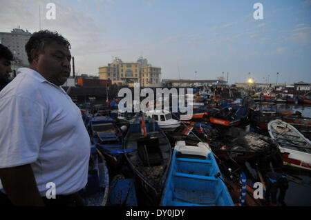 Iquique, Cile. 2 Apr 2014. Un uomo osserva danneggiato imbarcazioni a una dock dopo un terremoto di Iquique di Tarapaca regione nel nord del Cile, il 2 aprile 2014. Un 8.2-terremoto di magnitudine colpisci la costa nord del Cile Martedì, lasciando cinque morti e tre gravemente feriti, mentre migliaia di persone sono state evacuate a causa di un allerta tsunami. Credito: Pablo Vera/Agencia ONU/Xinhua/Alamy Live News Foto Stock