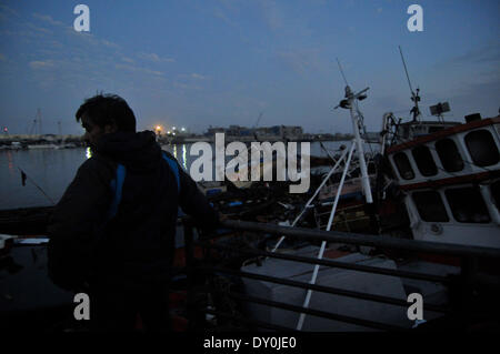 Iquique, Cile. 2 Apr 2014. Un uomo osserva danneggiato imbarcazioni a una dock dopo un terremoto di Iquique di Tarapaca regione nel nord del Cile, il 2 aprile 2014. Un 8.2-terremoto di magnitudine colpisci la costa nord del Cile Martedì, lasciando cinque morti e tre gravemente feriti, mentre migliaia di persone sono state evacuate a causa di un allerta tsunami. Credito: Pablo Vera/Agencia ONU/Xinhua/Alamy Live News Foto Stock